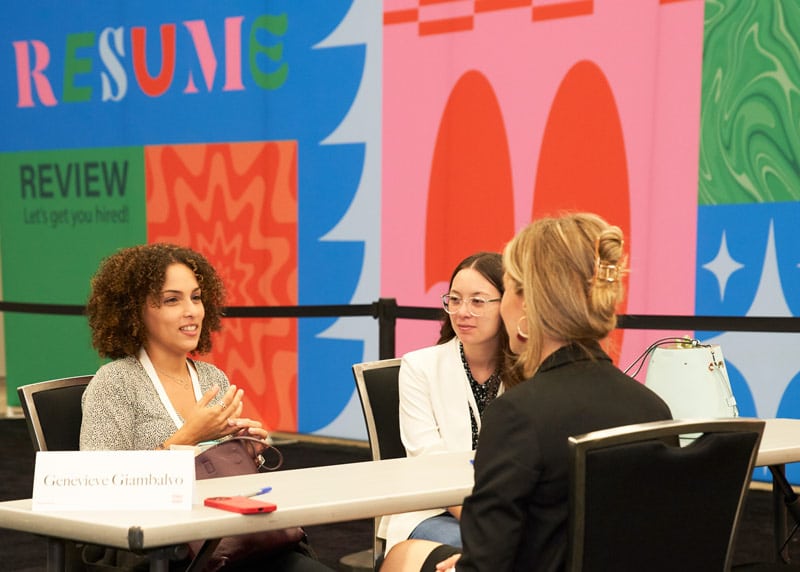 attendees getting their resumes reviewed at the TX Conference for Women